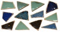 Triangular ceramic tiles with cracked glaze patterns in green, blue, and dark hues. Royalty Free Stock Photo