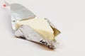 A triangular cheese wrapped in silver foil on white background