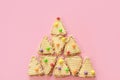 Triangular cookies are folded in shape of Christmas tree and have multi-colored round dragees on them.