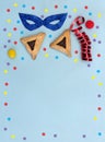 Triangular cookies with poppy seeds hamantasch or aman ears , candy, mask, serpentine, confetti for jewish holiday of purim