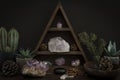 Triangular Crystal Shelf with Plants Foliage Gems and Jewellery on a Wooden Surface