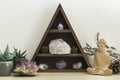 Triangular Crystal Shelf with Succulent Plants Foliage and Wooden Statue of Buddha