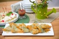 Triangular envelopes of phyllo dough filled with cheese and greens deep-fried