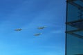 A triangular formation of a group of three russian military fighter jet planes flying high in blue sky during Vicotry Day parade