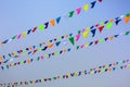 Triangular holiday multi colored flags are suspended on a tight string. Royalty Free Stock Photo