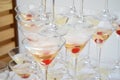 Triangular martini glasses, filled with champagne with cherries and liquid nitrogen, creating steam, shape of a pyramid