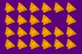 Triangular nachos on purple color background Royalty Free Stock Photo