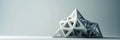 A triangular paper prism delicately folded into a precise and intricate shape