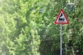 Triangular road sign with a picture of a black locomotive on a white background in a red frame. Warning sign for the presence of Royalty Free Stock Photo