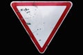 Triangular scratched red border road sign `Yield` isolated on bl