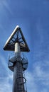 Triangular sign on a high steel pole