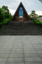 Triangular Timber Chapel atop Wide Symmetrical Staircase within Lush Landscape Royalty Free Stock Photo