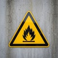 Triangular warning sign with a black flame symbol indicating flammable Royalty Free Stock Photo