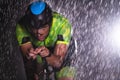 A triathlete braving the rain as he cycles through the night, preparing himself for the upcoming marathon. The blurred