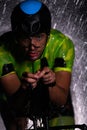 A triathlete braving the rain as he cycles through the night, preparing himself for the upcoming marathon. The blurred