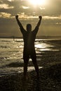 Triathlete celebrating on beach.