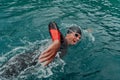 A triathlete in a professional swimming suit trains on the river while preparing for Olympic swimming Royalty Free Stock Photo