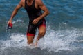 Triathlete swimmer running out of ocean finishing swim race