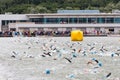 Triathletes swim on start of the triathlon competition in Moscow River and viewers behind the scene