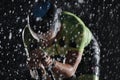 Triathlon athlete riding bike fast on rainy night