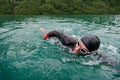 Triathlon athlete swimming on lake wearing wetsuit