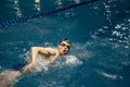 Triathlon athlete trains to swim in the pool . White man swimming in blue water banner panorama. Sports and fitness Royalty Free Stock Photo