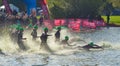 Triathlon swimmers entering open water swim stage.