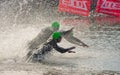 Triathlon swimmers entering open water swim stage.