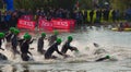 Triathlon swimmers entering open water swim stage.