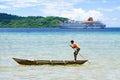 Native boy paddling handmade canoe in front of cruise liner, Solomon Islands Royalty Free Stock Photo