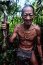 Tribal elder Toikot collecting materials fruits and plants in the jungl