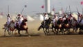 Tribal horsemen cavalry charging, twirling and firing rifles at traditional festival Tbourida or Fantasia