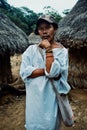 Tribal kogi man in front of ceremonial buildings in the middle of the cloudfor