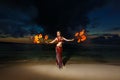 Tribal style girl on a tropical beach dancing with fire at sunset. Royalty Free Stock Photo