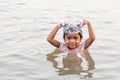 Tribe Bru little girl is smiling and using shampoo while taking shower in the Mekong River in summer hot weather. Bru village,