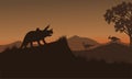 Triceratops and Eoraptor silhouette in hills Royalty Free Stock Photo