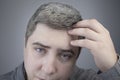 A trichologist examines a young manÃ¢â¬â¢s gray hair under a magnifying glass. Earlier bleaching of hair and pigment as a sign of low