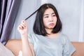 Trichotillomania (hair pulling disorder) with Asian woman pulling out hair for Stress relief