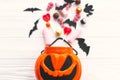 Trick or treat. Halloween candy spilled from jack o lantern bucket with skulls, black bats, ghost, spider decorations on white Royalty Free Stock Photo