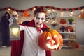 Spooky little boy dressed in Halloween vampire costume screams and scares looking at camera. Royalty Free Stock Photo