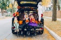 Trick or trunk. Children celebrating Halloween in trunk of car. Boy and girl with red pumpkins celebrating traditional October Royalty Free Stock Photo