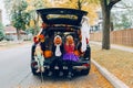 Trick or trunk. Children celebrating Halloween in trunk of car. Boy and girl with red pumpkins celebrating traditional October