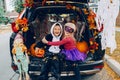 Trick or trunk. Children celebrating Halloween in trunk of car. Boy and girl with red pumpkins celebrating traditional October Royalty Free Stock Photo