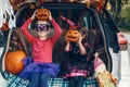 Trick or trunk. Children siblings sisters celebrating Halloween in trunk of car. Friends kids girls preparing for October holiday