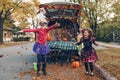 Trick or trunk. Children siblings sisters celebrating Halloween in trunk of car. Friends kids girls preparing for October holiday