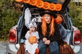 Trick or trunk. Trunk or treat. Happy children in costumes celebrating Halloween party eating candies in decorated trunk of car. Royalty Free Stock Photo