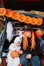 Trick or trunk. Trunk or treat. Happy children in costumes celebrating Halloween party eating candies in decorated trunk of car. Royalty Free Stock Photo