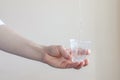 A trickle of water pours into a plastic transparent Cup