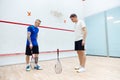 Tricks. Two men standing on squash court and playing. Leisure activity, fun and sportive time Royalty Free Stock Photo