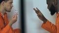 Tricky multiracial prisoners playing cards in camera, hazard entertainments